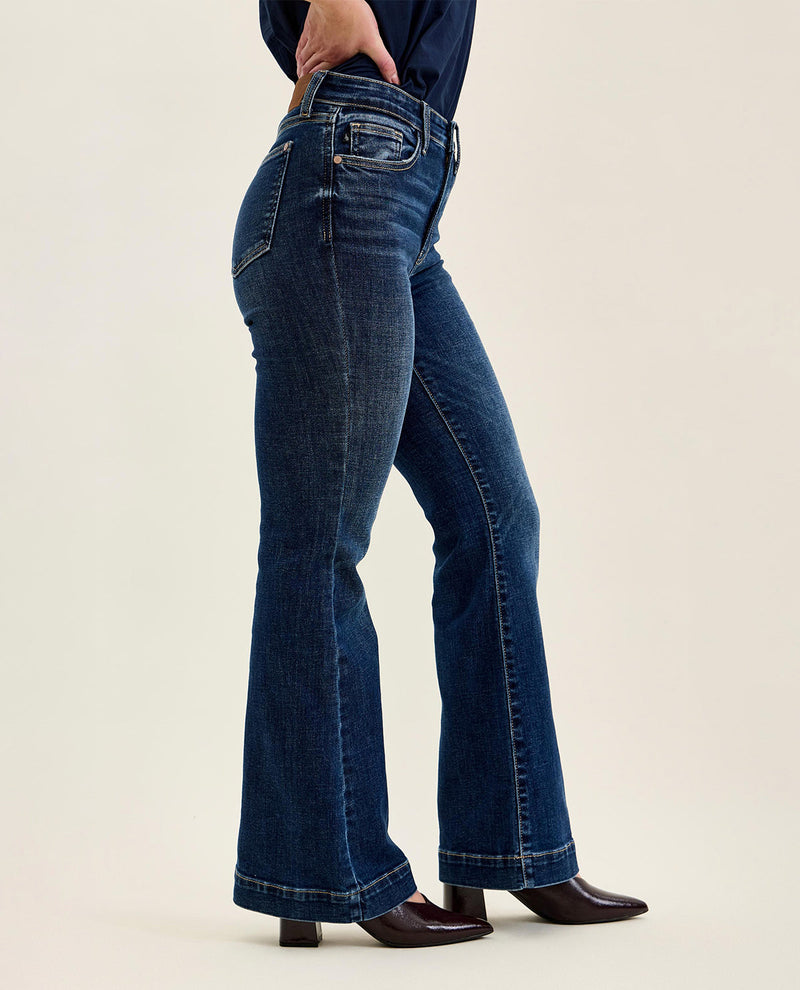 Person wearing blue jeans on a beige background