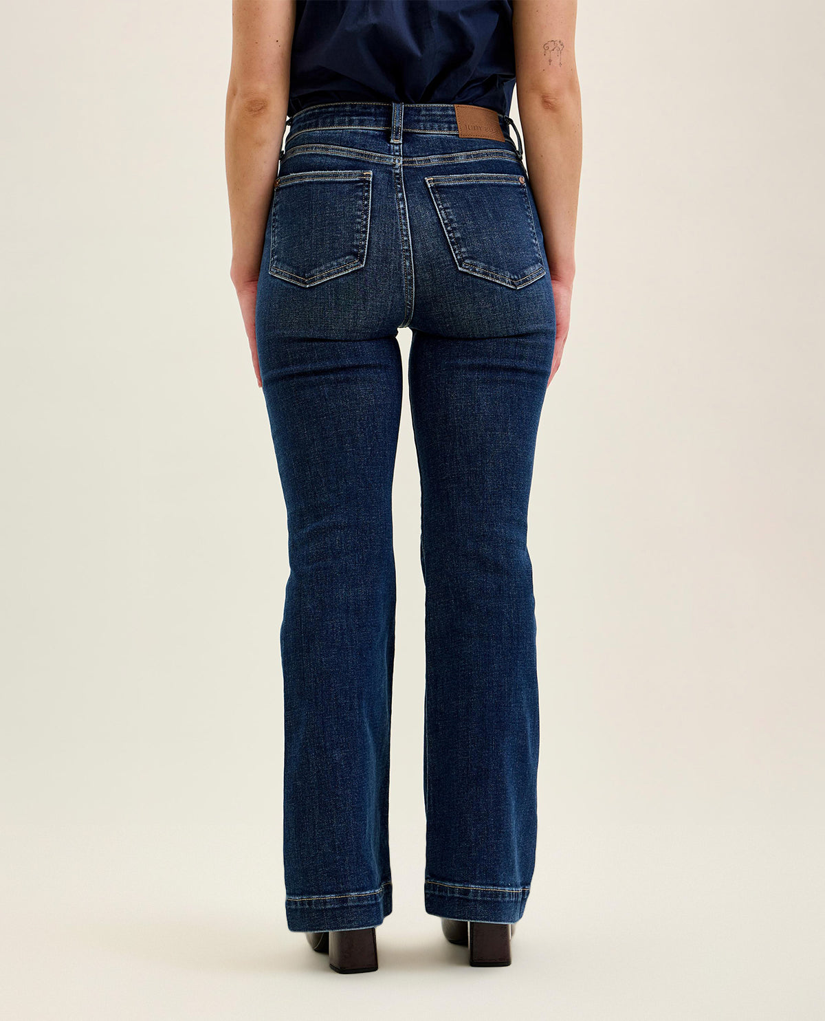 Person wearing blue jeans on a plain background