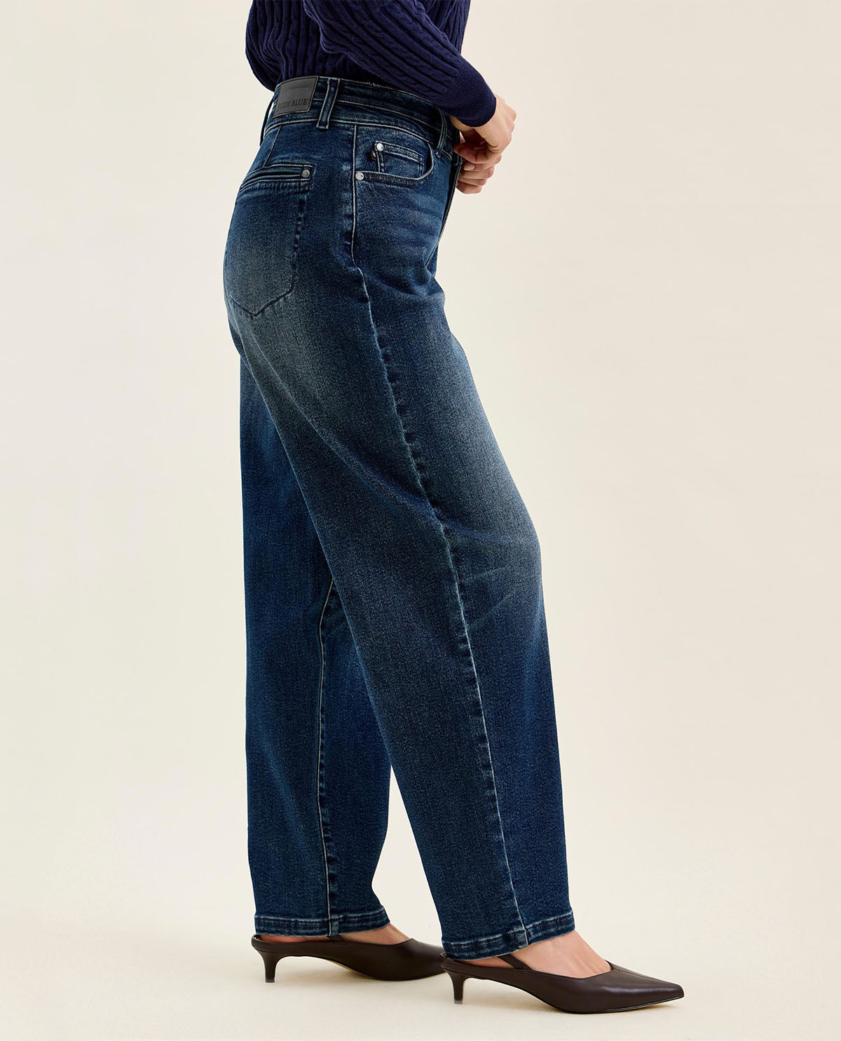 Person wearing blue jeans on a beige background