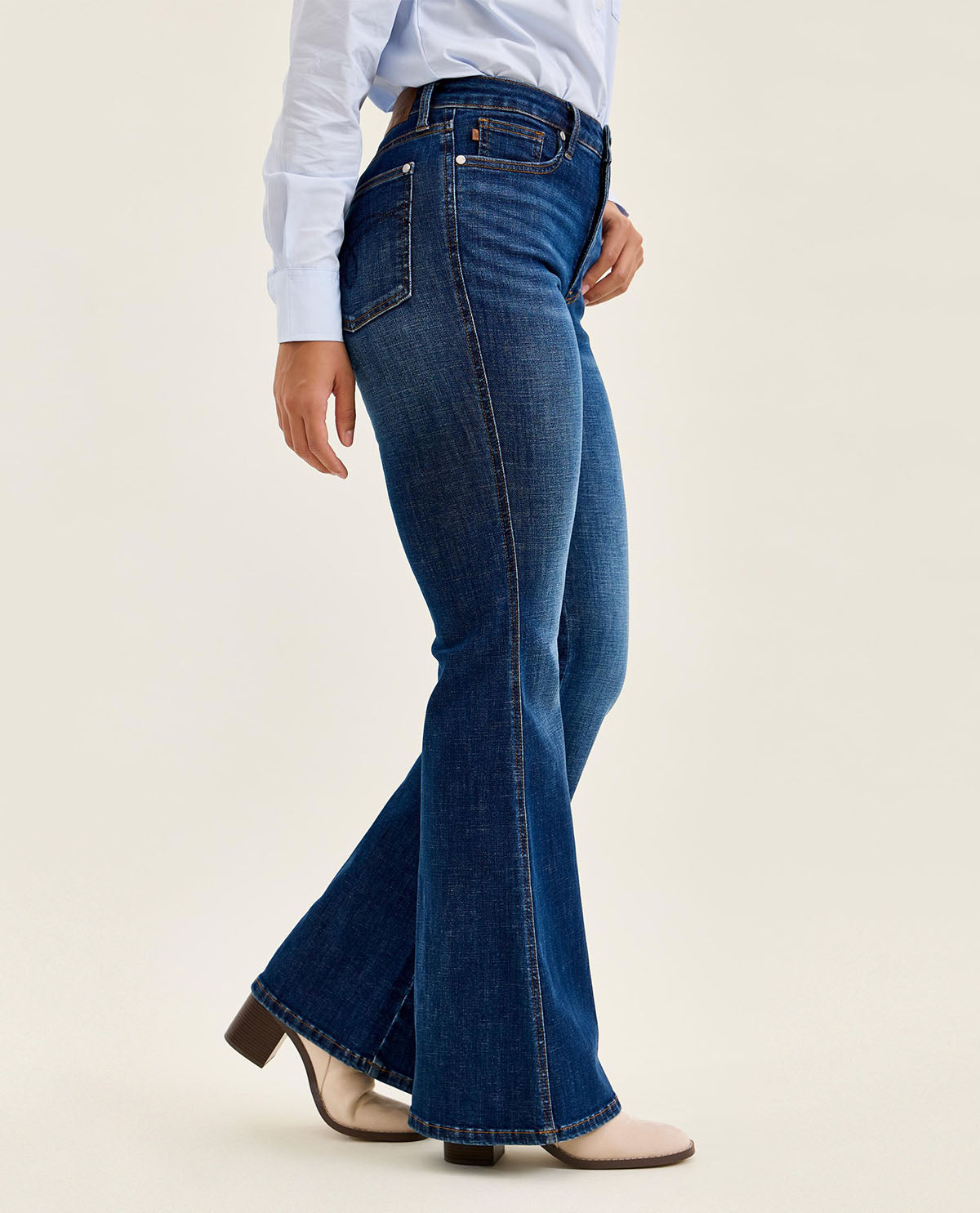 Person wearing blue jeans on a plain background