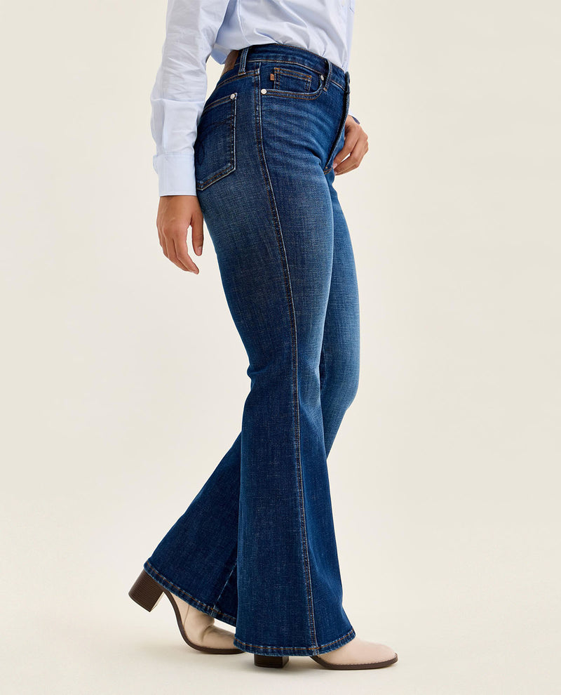 Person wearing blue jeans on a plain background