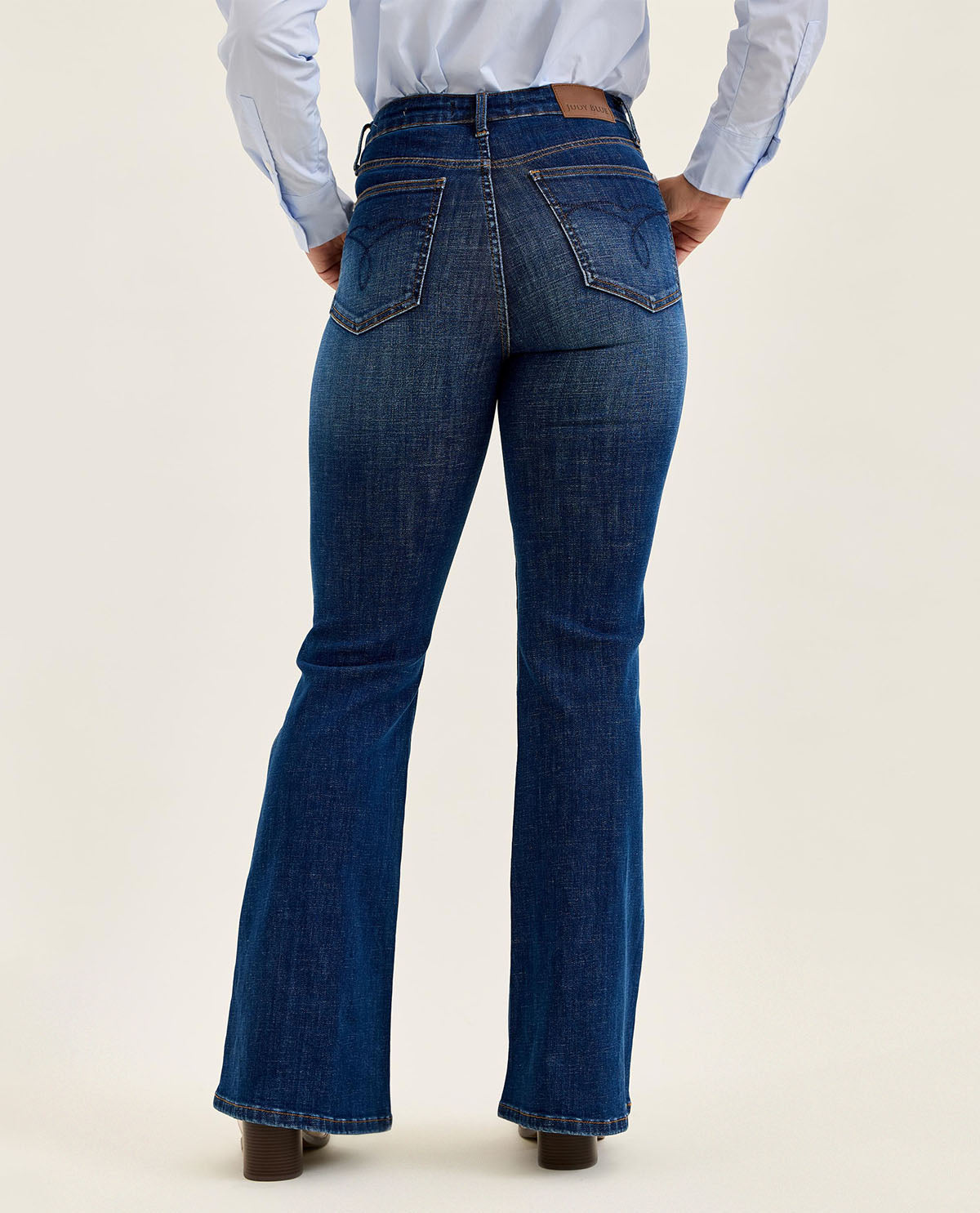 Person wearing blue jeans on a beige background