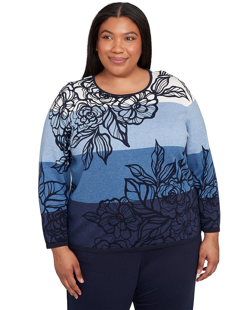 Woman wearing a blue and navy floral-patterned sweater on a white background