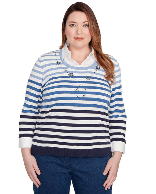 Woman wearing a blue and white striped sweater with a decorative pattern on a white background