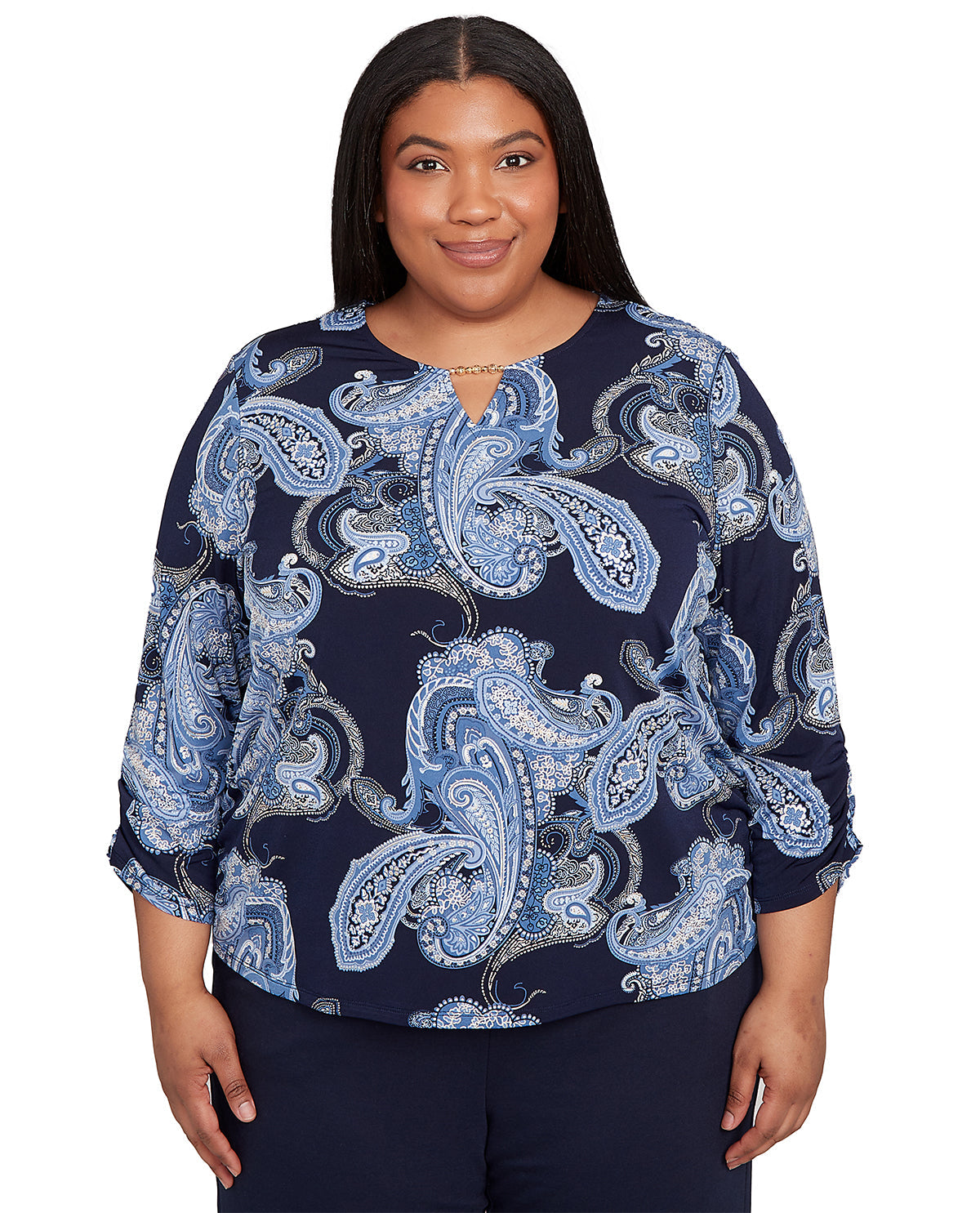Woman wearing a navy blue blouse with blue paisley pattern on a white background