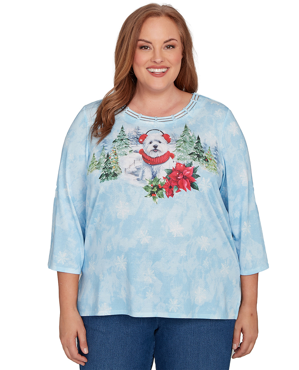 A woman wearing a light blue three-quarter sleeve top with a Christmas dog graphic, paired with blue jeans, against a plain white background.