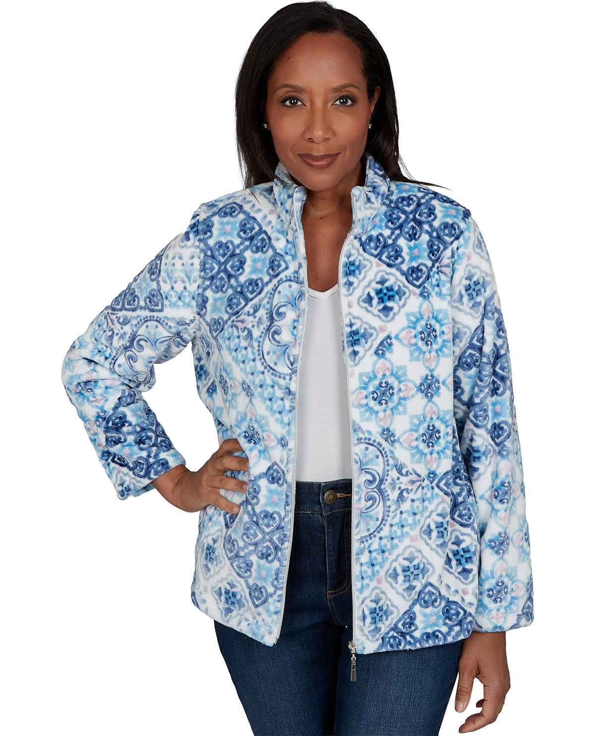 A woman modeling a blue and white patterned zip-up jacket over a white top and dark blue jeans, photographed against a plain white background.
