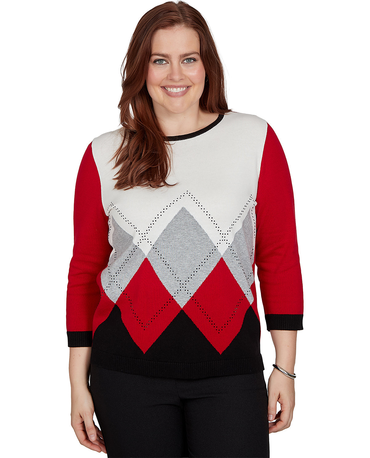 A woman modeling a three-quarter sleeve sweater with a color-blocked design featuring red sleeves, a cream upper chest, and an argyle pattern in cream, gray, and red on the lower body.