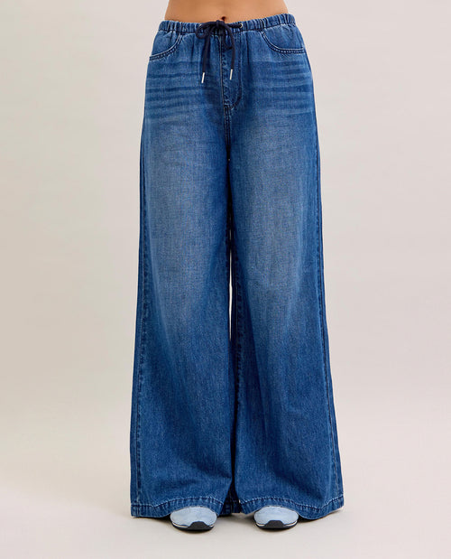 Blue wide-leg jeans on a plain background
