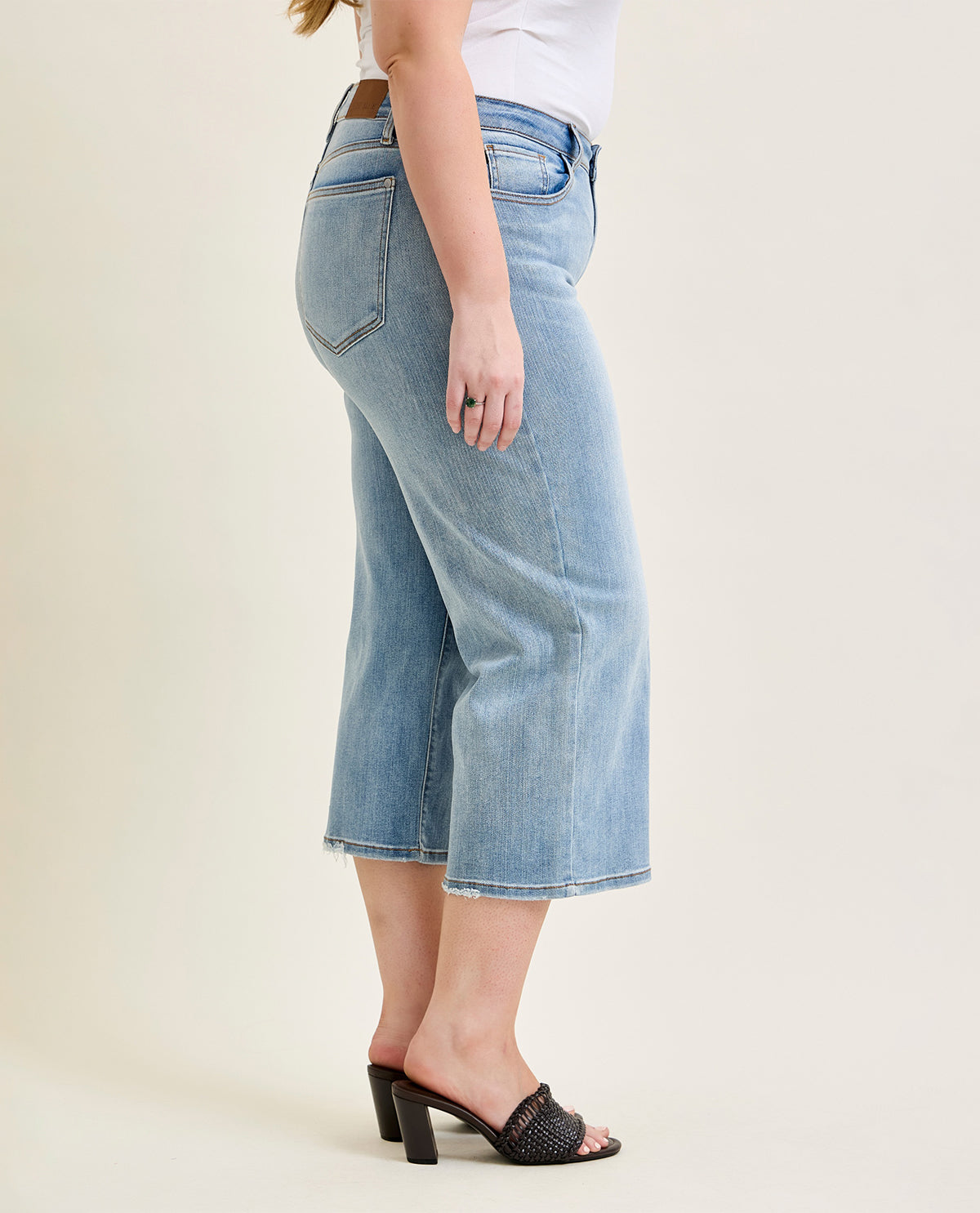 Person wearing light blue jeans on a plain background