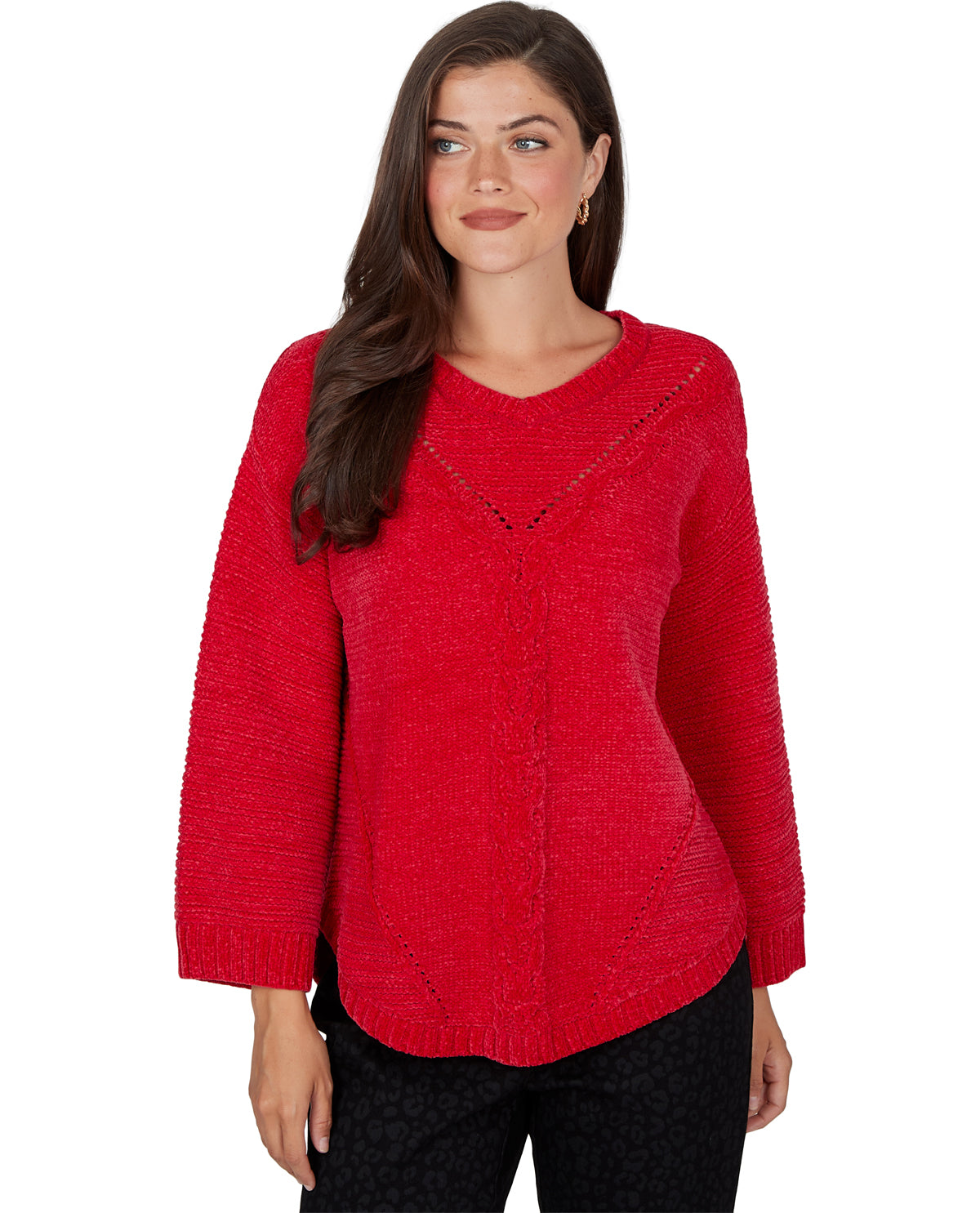 A woman modeling a bright red textured knit sweater with a V-neckline and subtle black lace detailing, paired with black patterned pants against a plain white background.