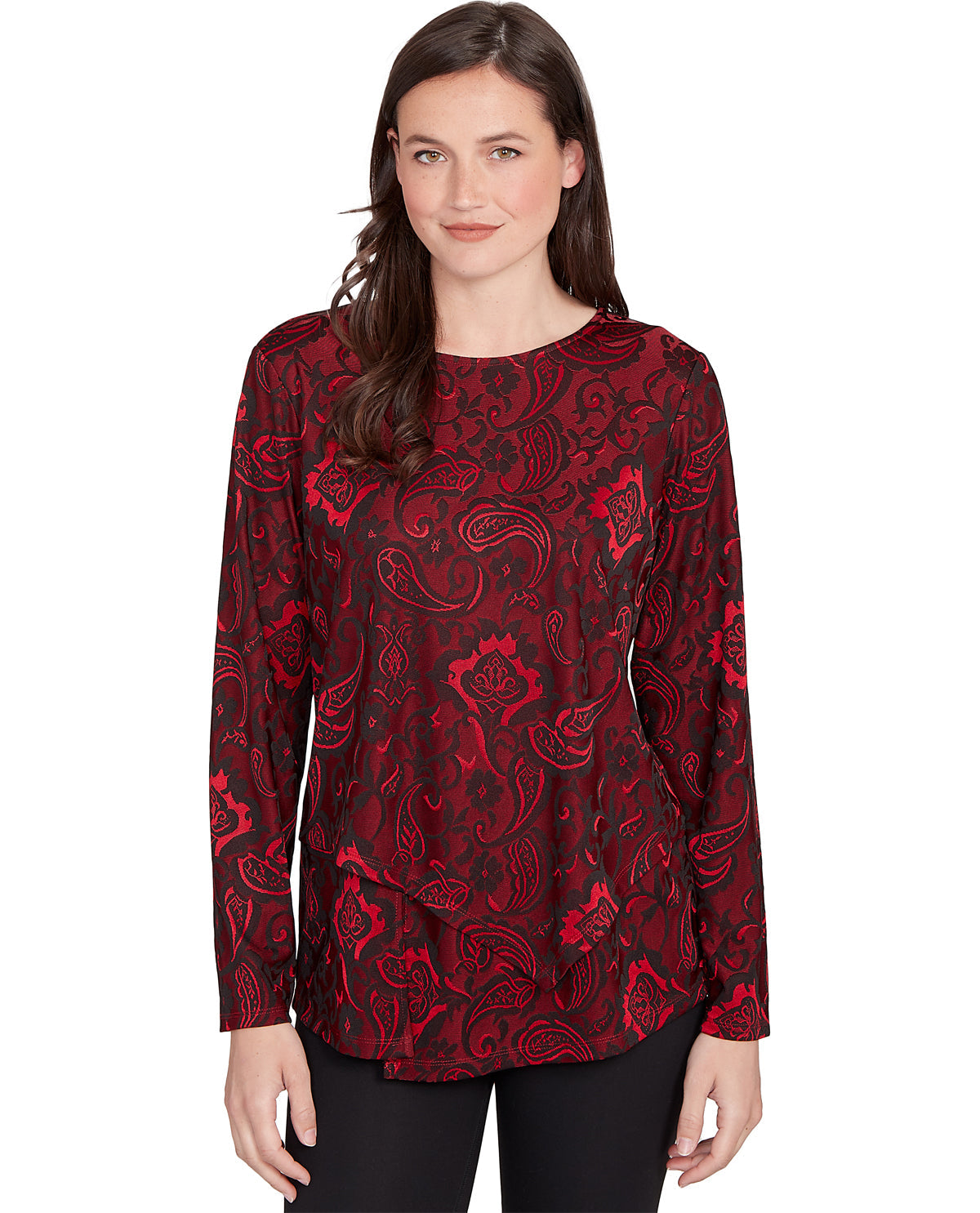 A woman modeling a long-sleeve top with a red and black paisley pattern, paired with black pants, against a plain white background.