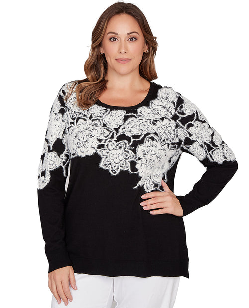 Woman wearing a black sweater with white lace details on a white background