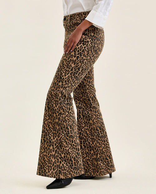 Leopard print pants worn by a person on a beige background