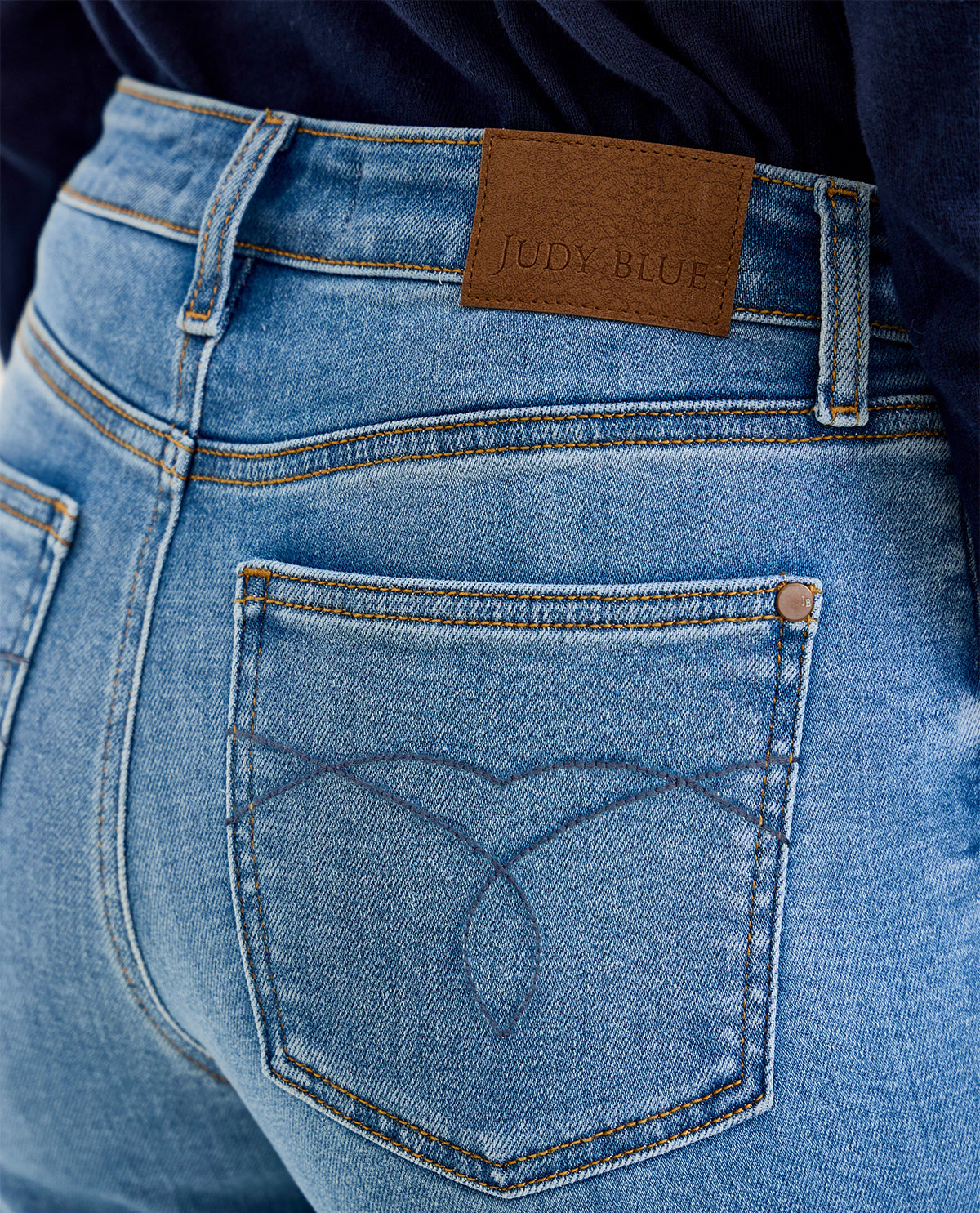 Close-up of blue jeans with a Judy Blue label on the back pocket.