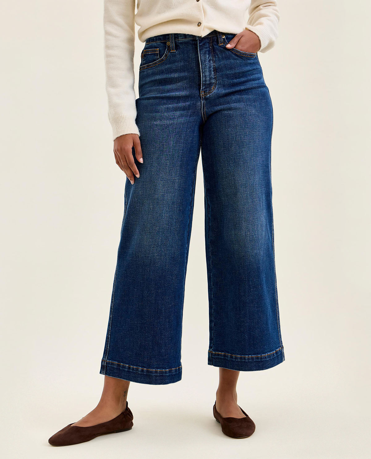 Person wearing blue wide-leg jeans on a white background