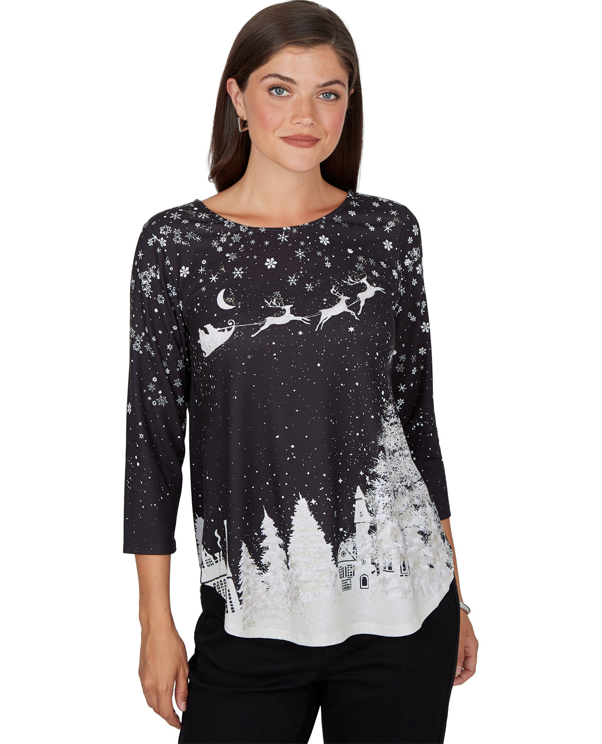 A woman modeling a black three-quarter sleeve top with a white Christmas print featuring snowflakes, a crescent moon, reindeer, and a snowy village scene.