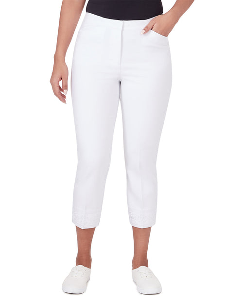 White cropped capri pants shown on a model from the waist down, paired with a black top and white slip-on shoes against a plain white background.