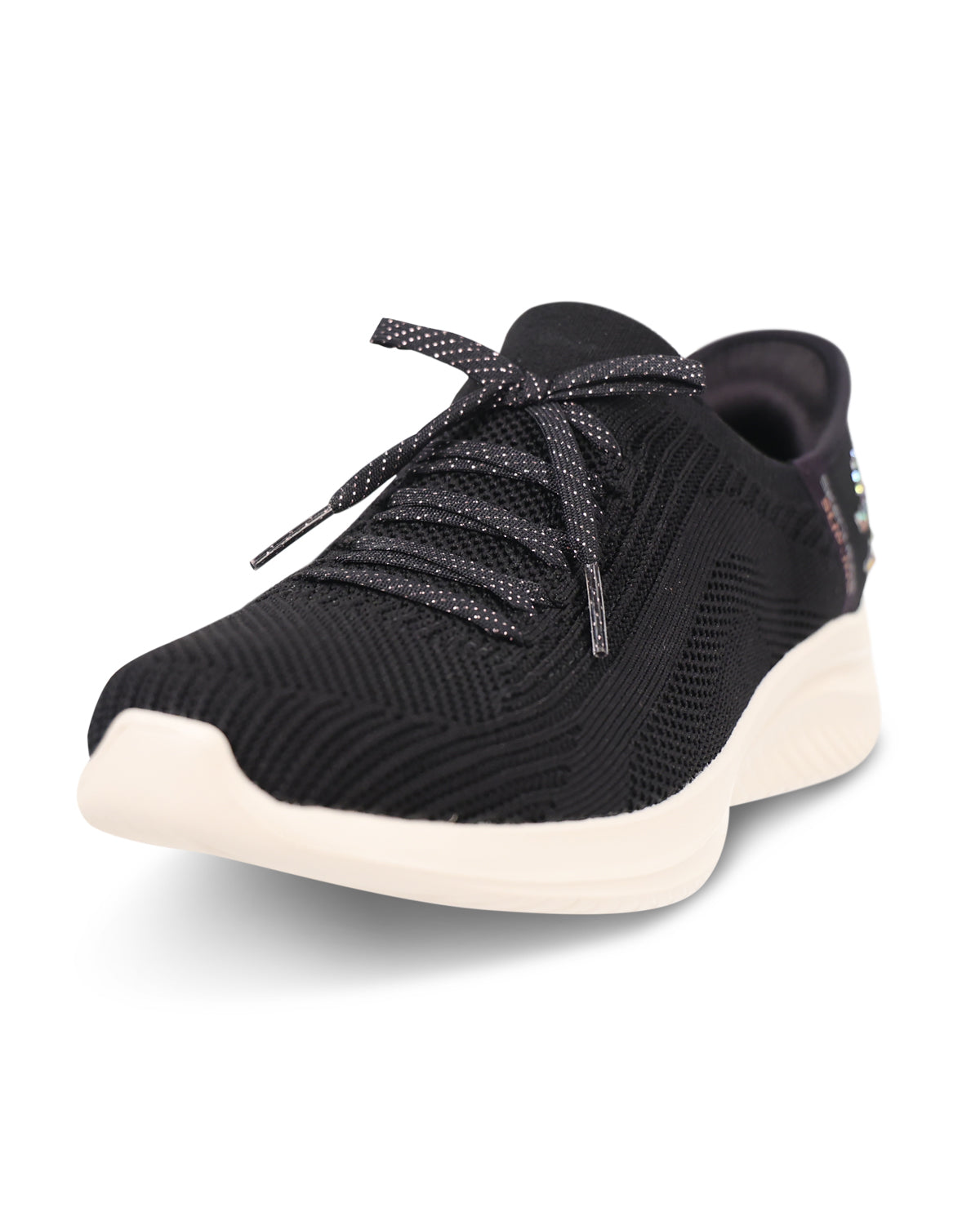 A black knit athletic sneaker with textured knit uppers, matching black laces with subtle speckles, and a thick cream-colored sole, shown from a three-quarters angle on a white background.
