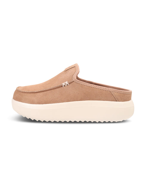 A single slip-on clog shoe in tan suede with a thick cream-colored sole, shown from a side profile view against a plain white background.