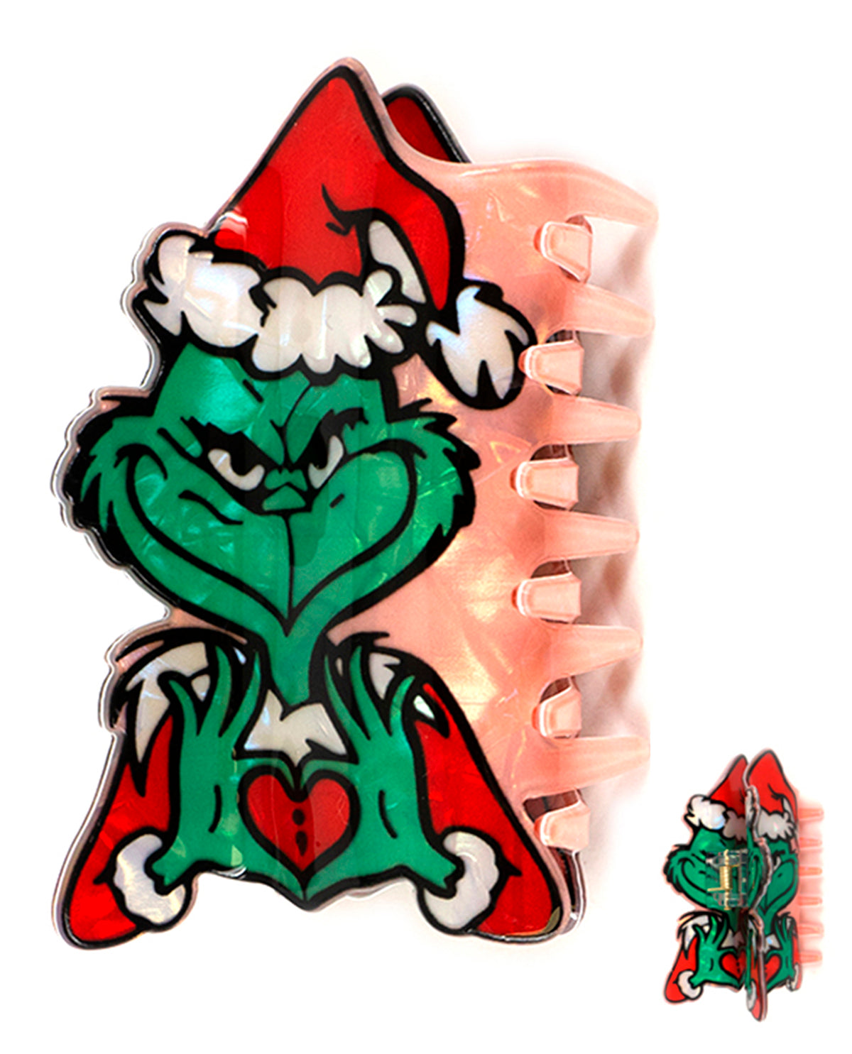 A translucent peach-colored hair claw clip featuring a green Grinch character design wearing a red Santa hat and red cape with white trim, shown on a white background with a smaller inset of the clip closed.