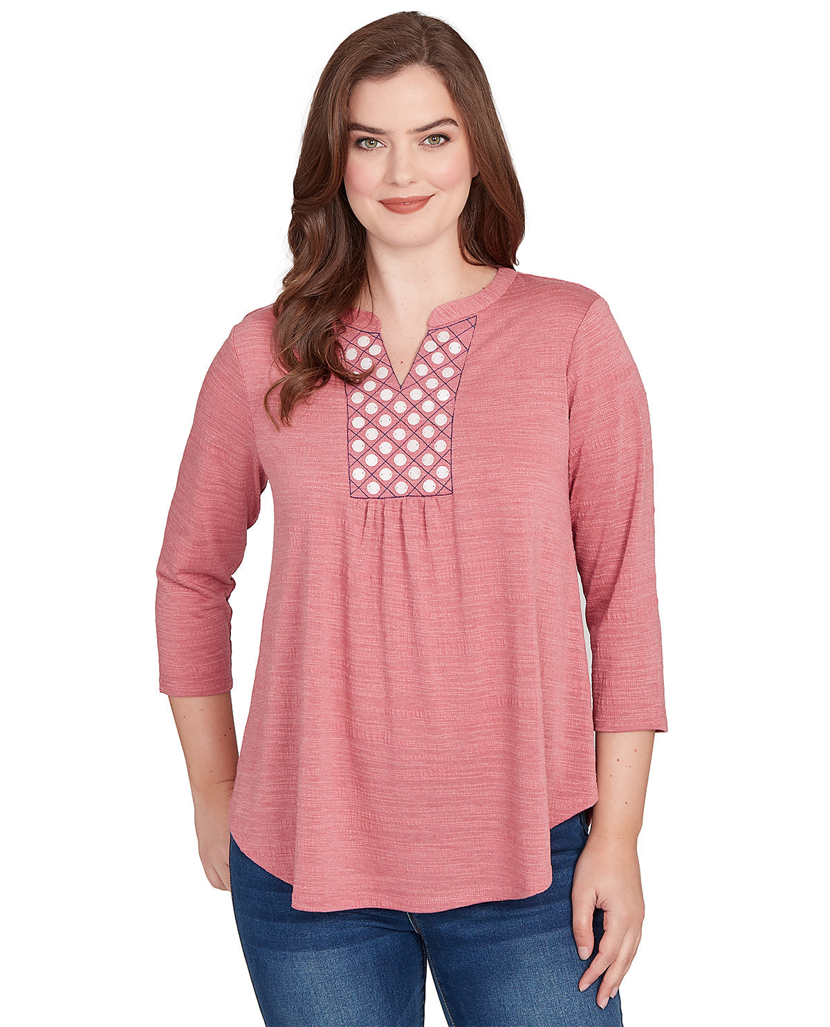 Woman wearing a pink long-sleeve top with lace detailing on a white background