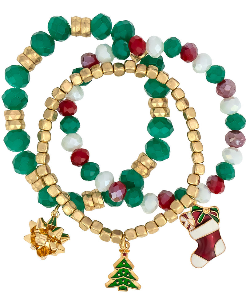 Three beaded stretch bracelets with gold-tone metal beads and holiday-themed charms, including a green Christmas tree, a red and white stocking, a gold bow, and faceted green, red, and white beads.