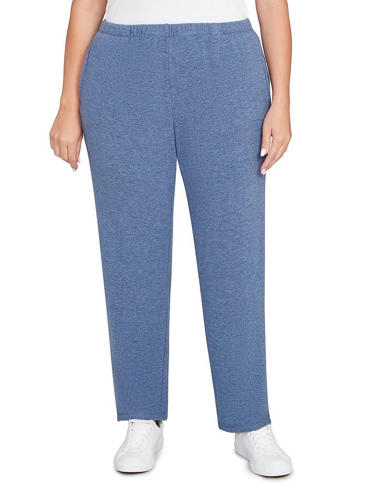 A person wearing heathered blue straight-leg sweatpants with a white top and white sneakers, shown from the waist down against a plain white background.