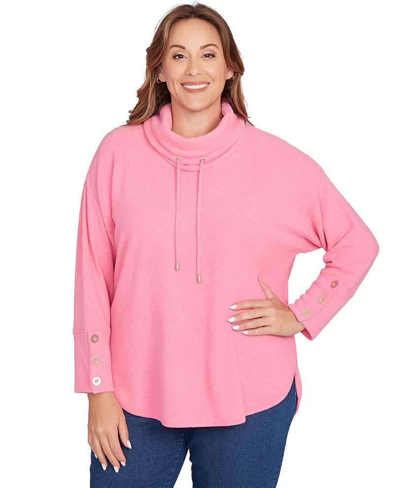 Woman wearing a pink cowl-neck sweater with buttons on a white background
