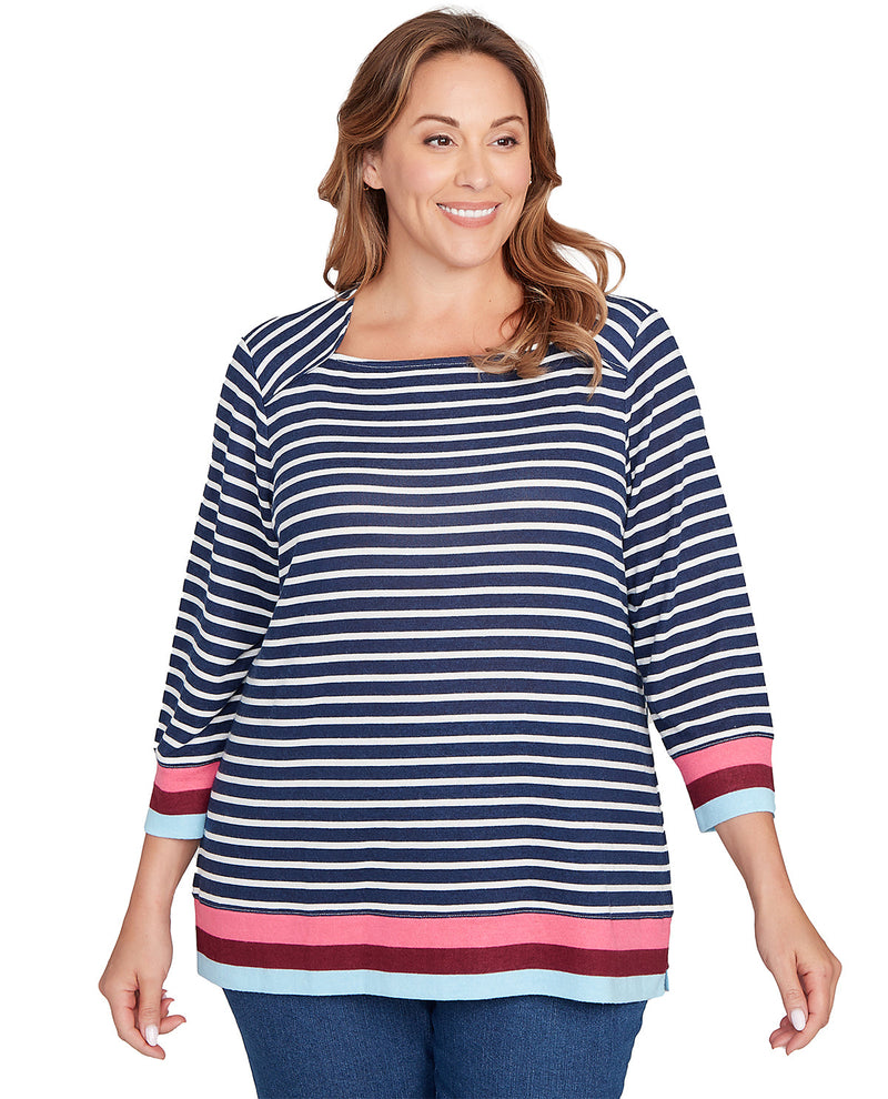 Woman wearing a blue and white striped shirt with pink accents on a white background
