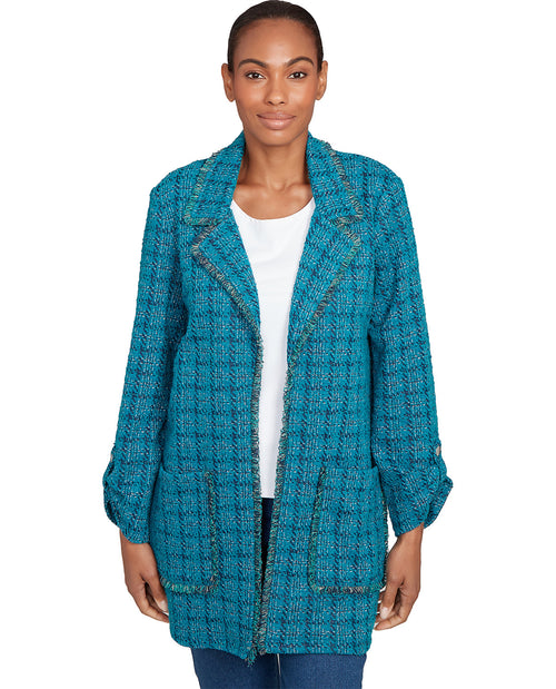 Woman wearing a teal textured jacket on a white background