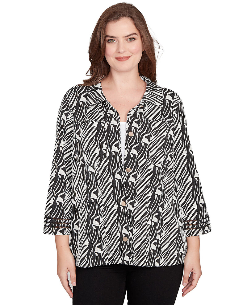 Woman wearing a black and white patterned blouse on a white background