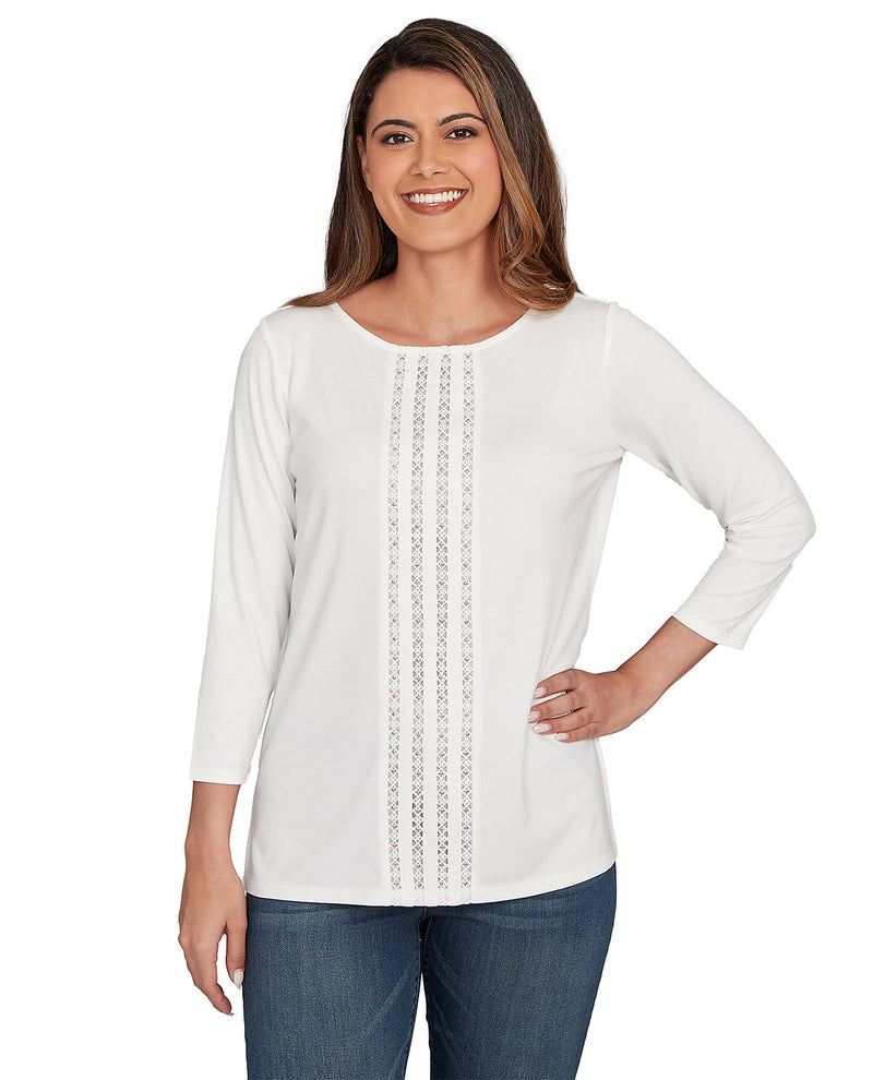 Woman wearing a white long-sleeve top with lace details on a white background