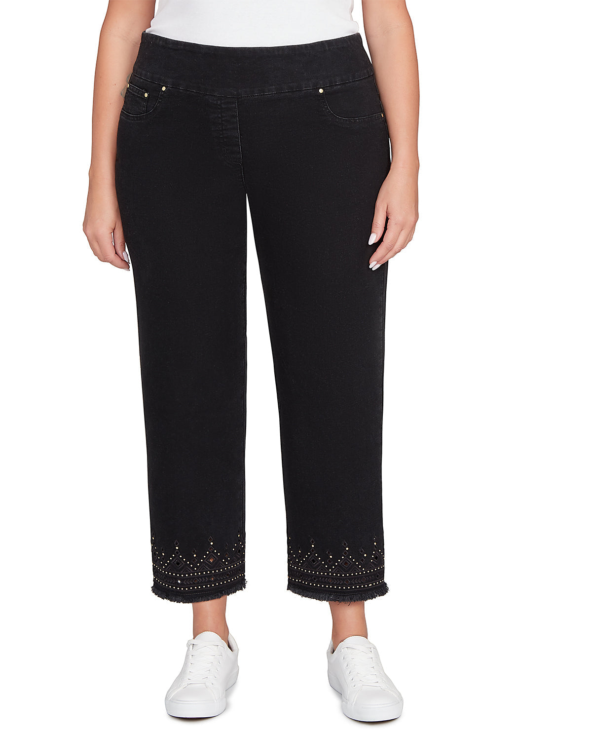 Person wearing black jeans with decorative studs on a white background