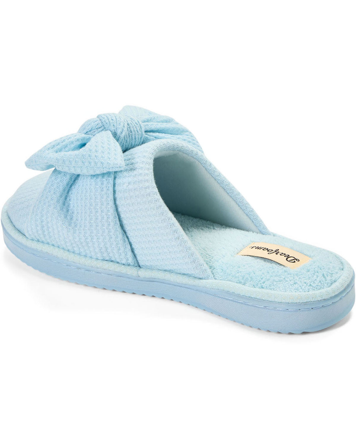 A light blue textured slip-on slipper with a large bow detail on the top and a small tan brand tag on the insole, shown against a plain white background.