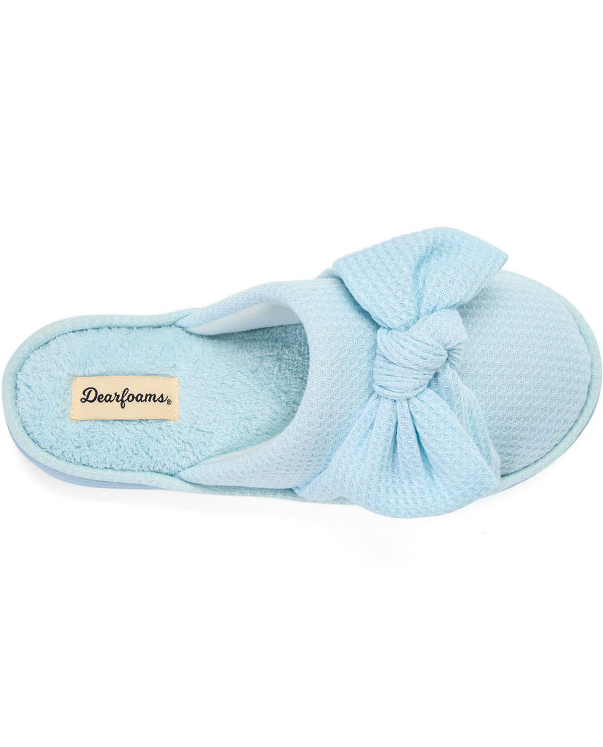 A single light blue slip-on house slipper with a large textured fabric bow on the top and a plush insole, shown on a plain white background. The brand name 'Dearfoams' is visible on a small beige tag on the heel.