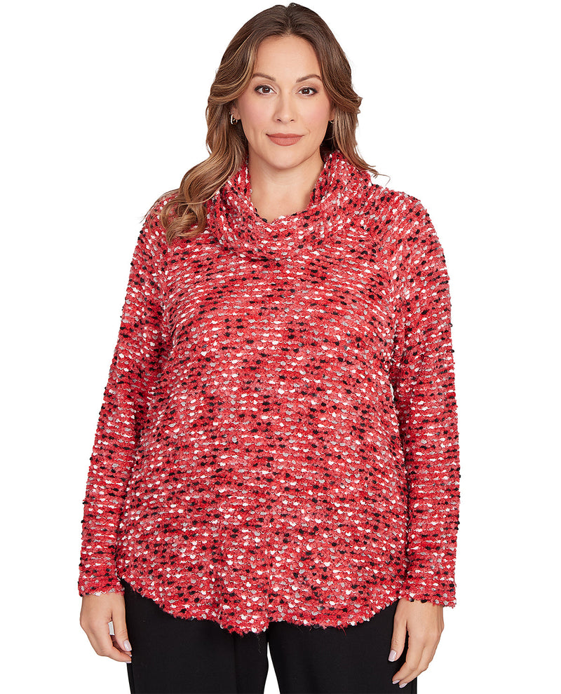 Woman wearing a red and black patterned cowl-neck sweater on a white background