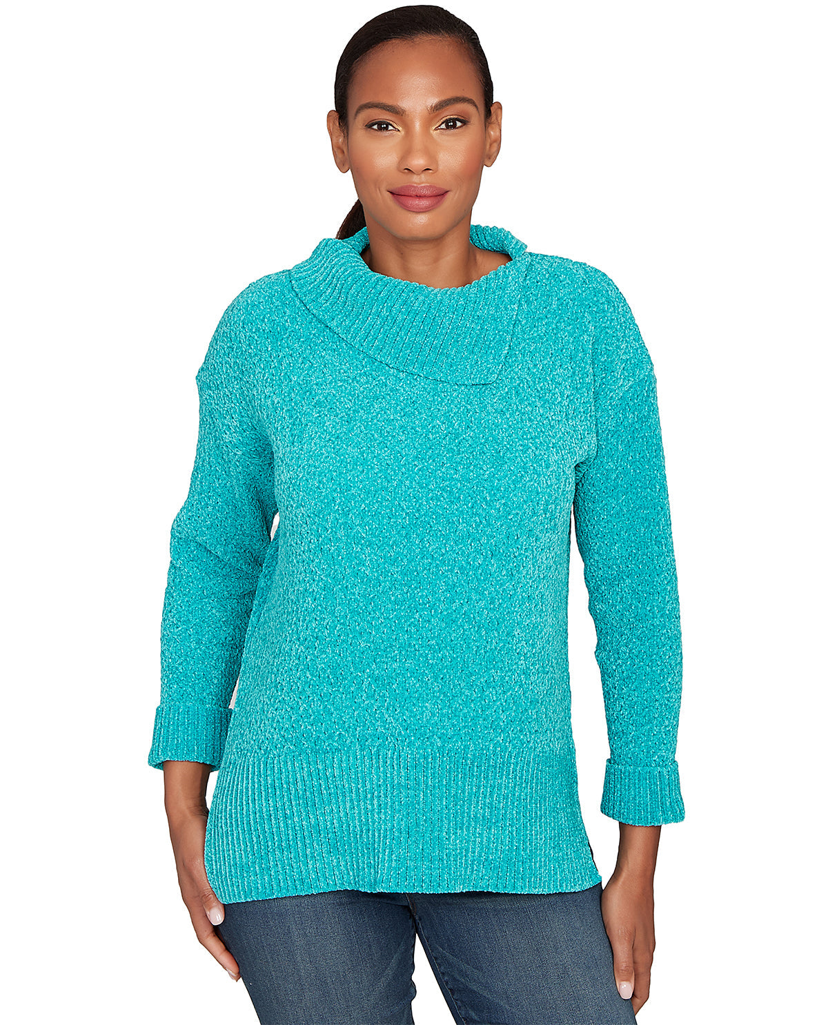 A woman wearing a turquoise knit sweater with a wide draped neckline and ribbed cuffs, paired with blue jeans, against a plain white background.
