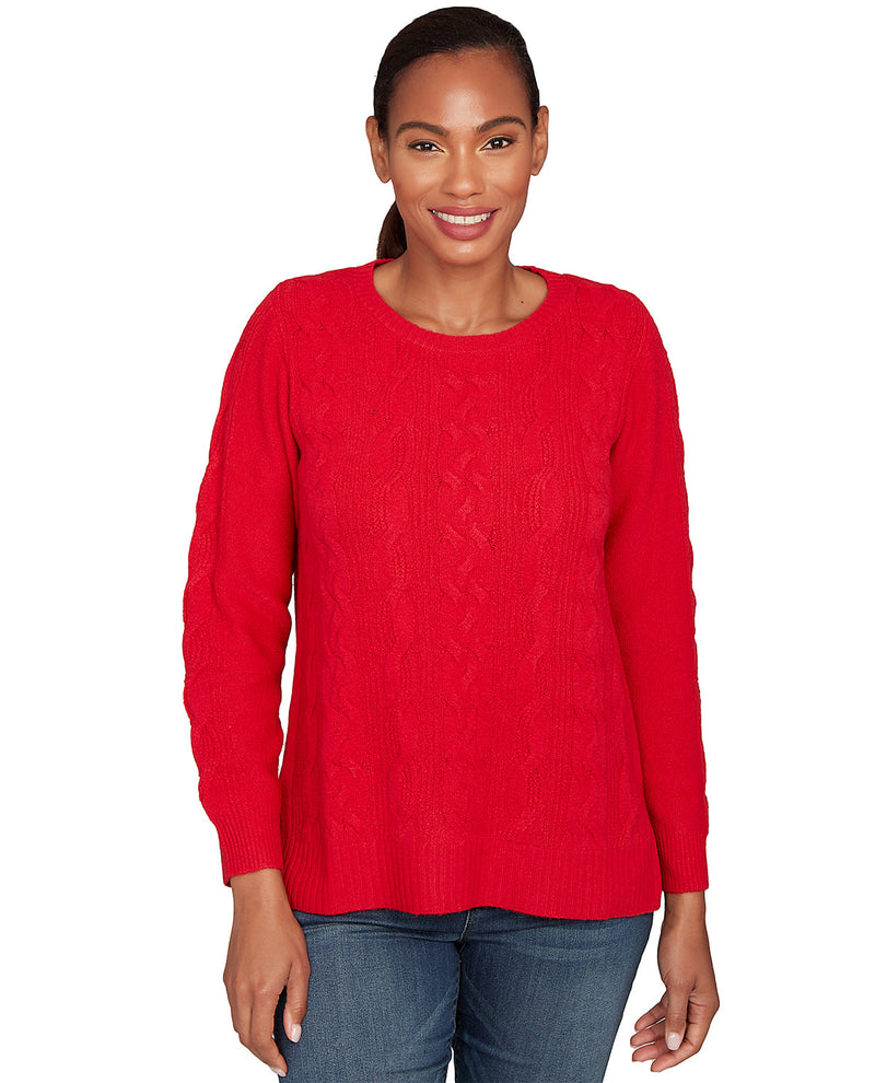 Woman wearing a red cable knit sweater on a white background