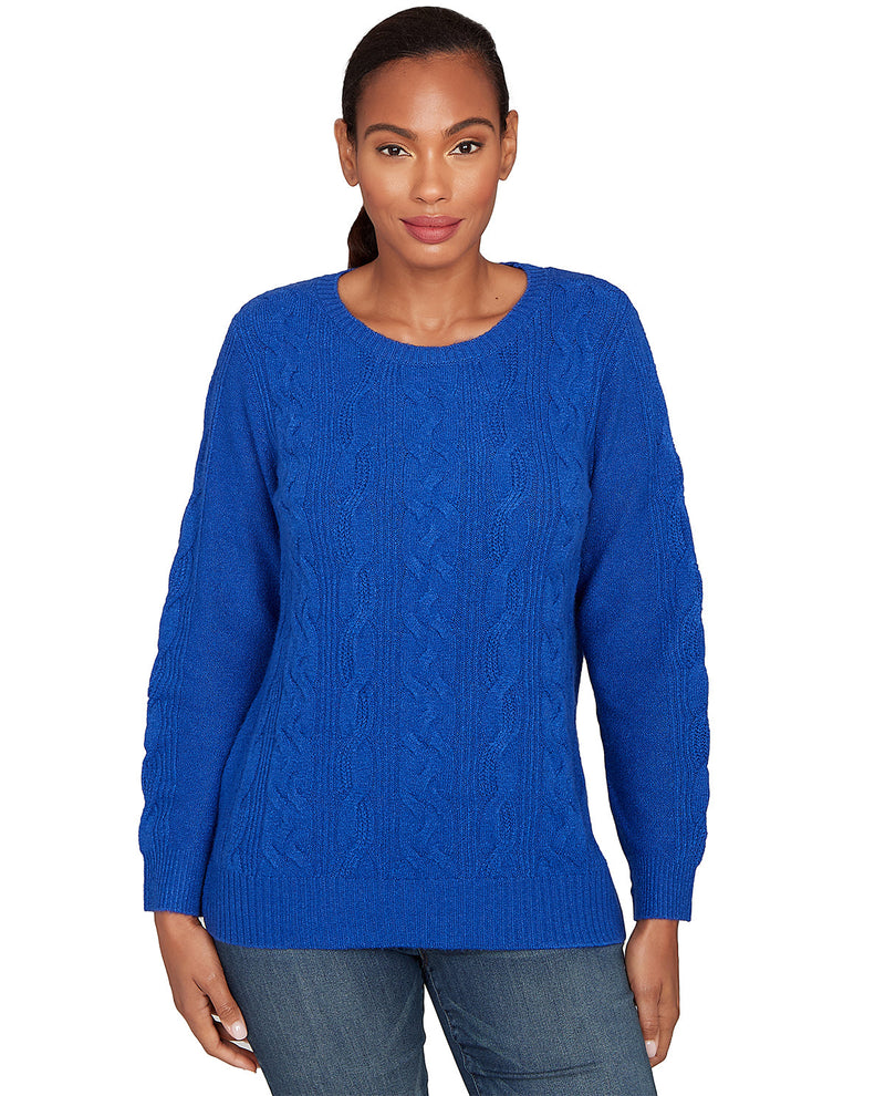 Woman wearing a blue cable knit sweater on a white background