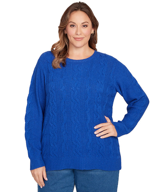 Woman wearing a blue cable knit sweater on a white background