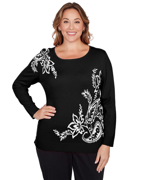 Woman wearing a black long-sleeve top with white floral patterns on a white background