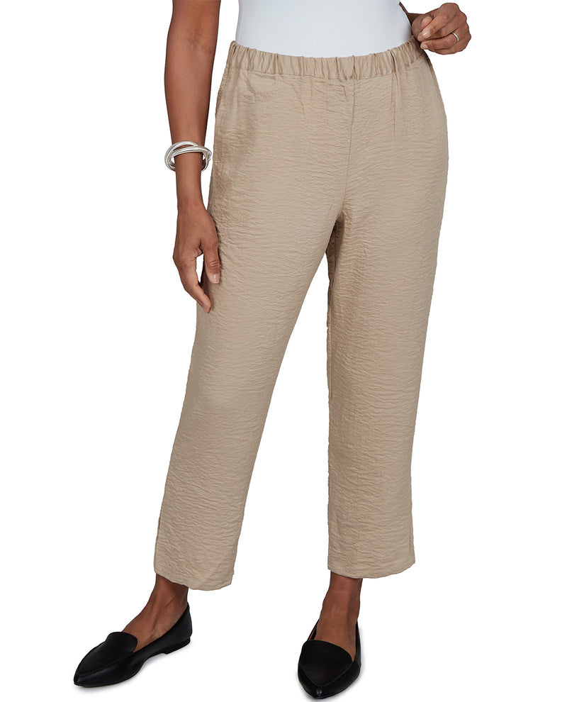 Beige pants worn by a person on a white background