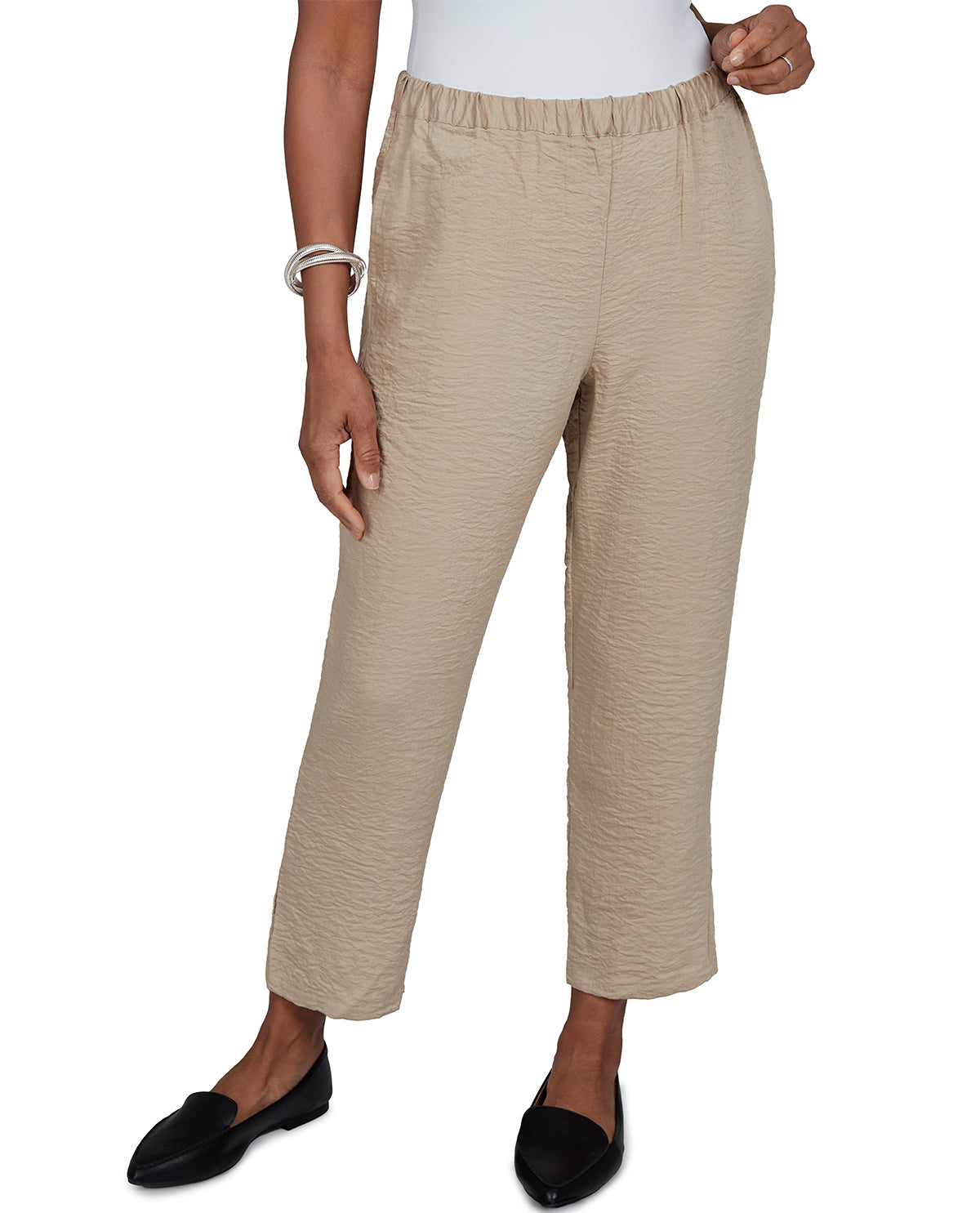 Beige pants worn by a person on a white background