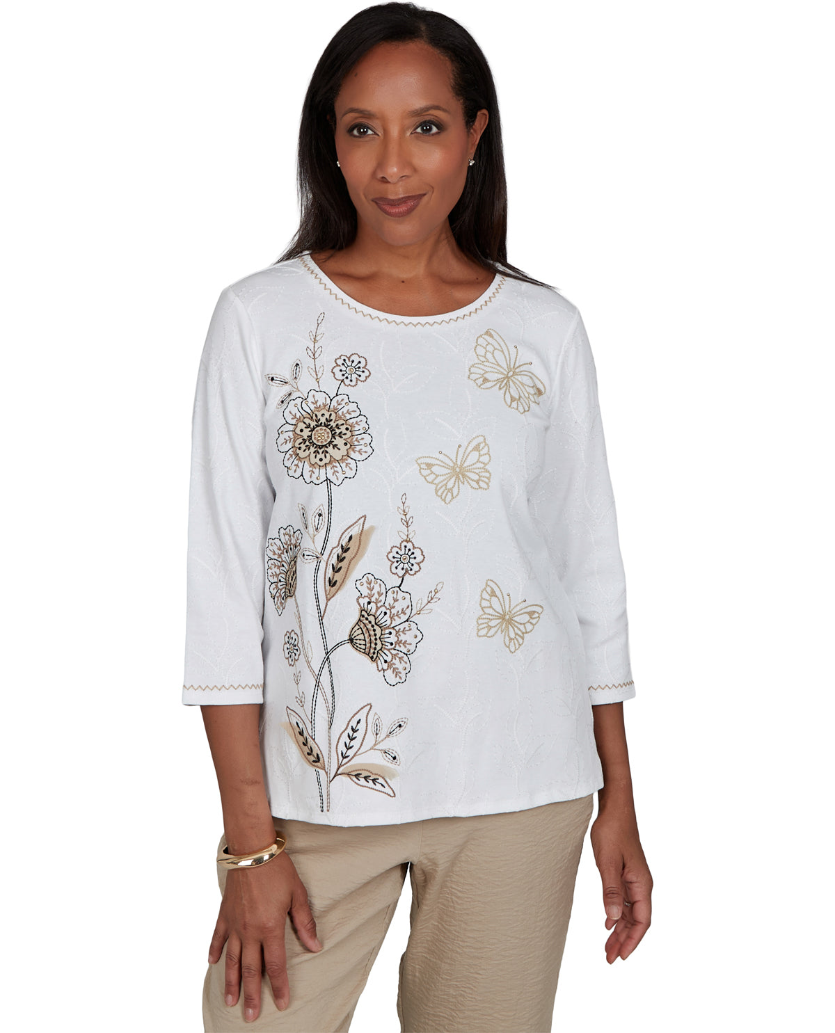 Woman wearing a white blouse with floral embroidery on a white background
