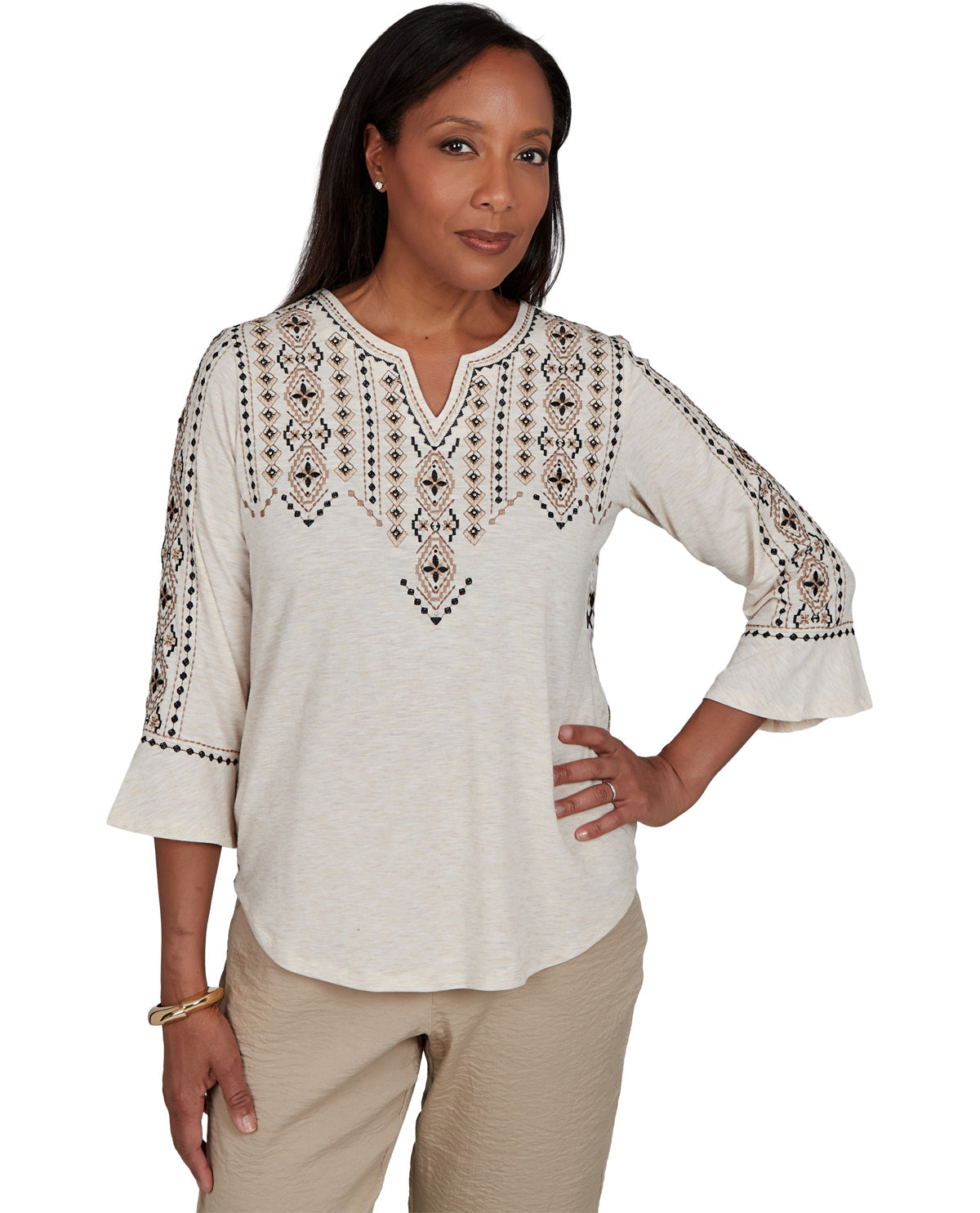 Woman wearing a white blouse with black embroidery on a white background