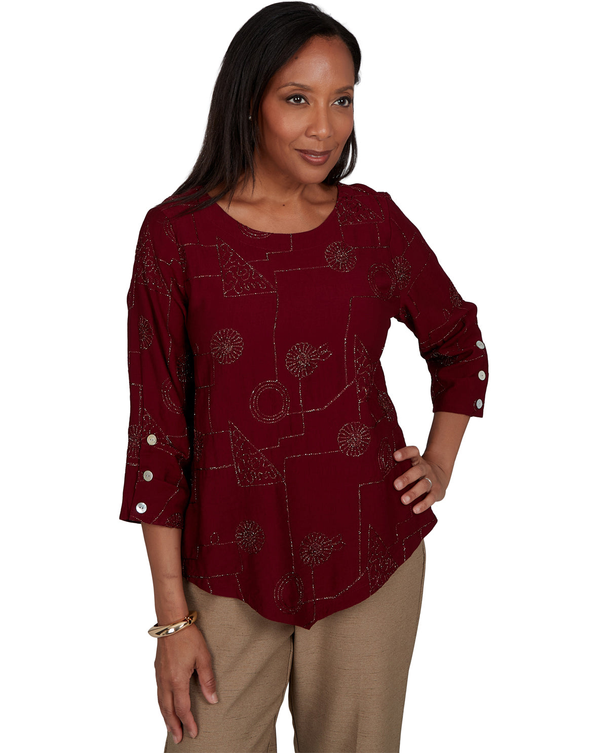 Woman wearing a burgundy patterned top with white buttons on a white background