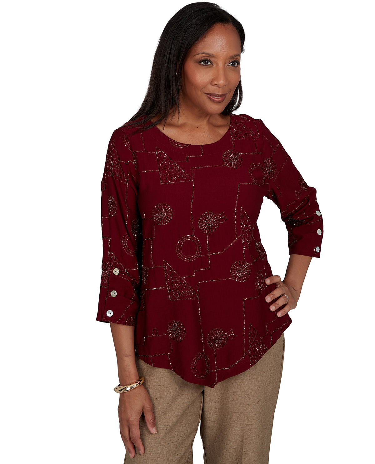 Woman wearing a burgundy patterned blouse with white buttons on a white background