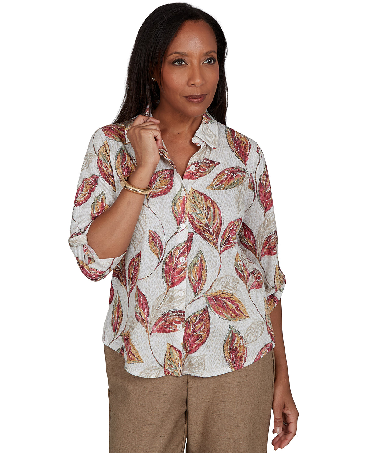 Woman wearing a patterned blouse with rolled-up sleeves on a white background
