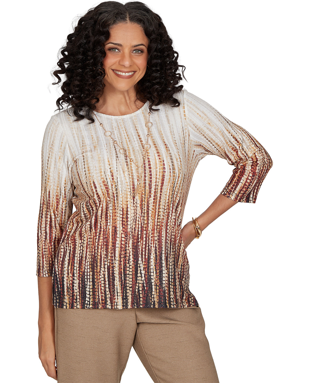 Woman wearing a patterned top and beige pants on a white background